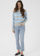 Woman wearing a grey and blue striped pullover on a white background