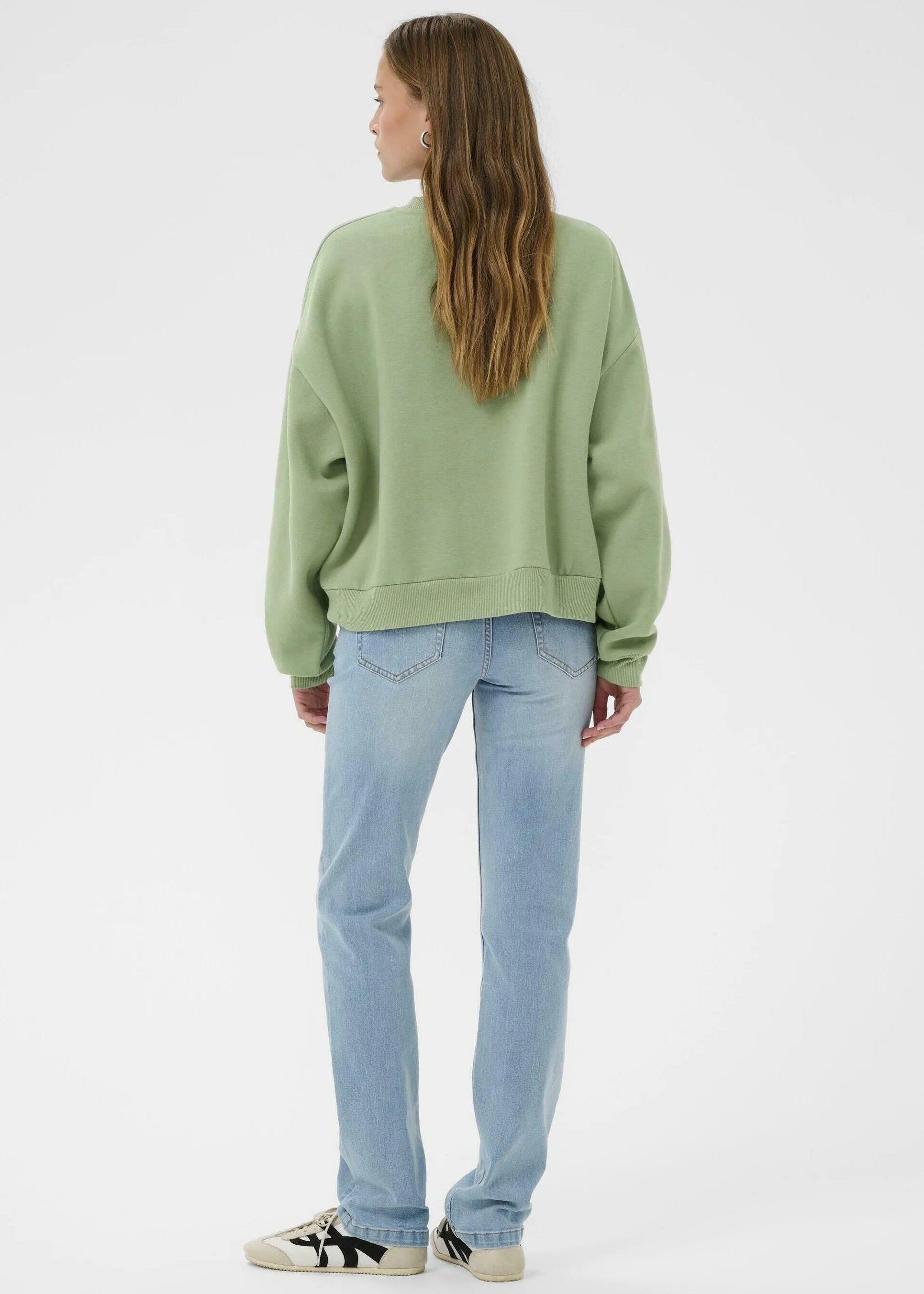 Woman wearing a green sweatshirt on a white background