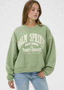Woman wearing a green sweatshirt on a white background
