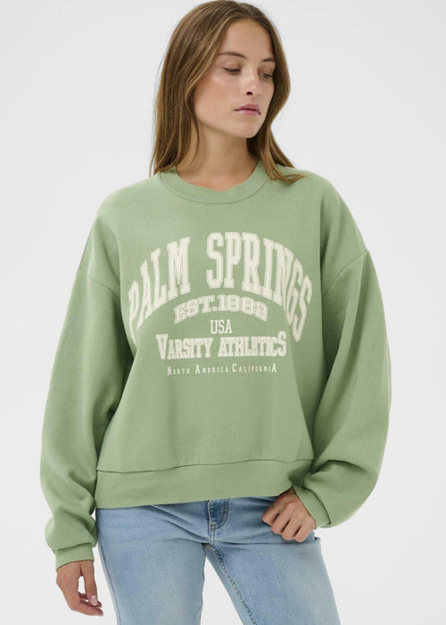 Woman wearing a green sweatshirt on a white background