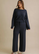 Navy blue wide-leg pants worn by a person on a beige background