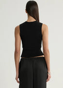 A woman shown from the back wearing a black sleeveless ribbed crop top and black wide-leg trousers against a plain light gray studio background.