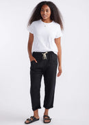 Woman wearing a white t-shirt and black pants on a white background