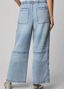 Woman wearing a white t-shirt and light blue jeans on a grey background