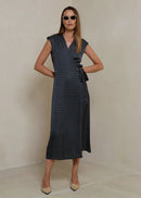 Woman wearing a black patterned dress on a light background