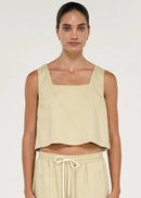 Women wearing short sleeveless beige top on white background