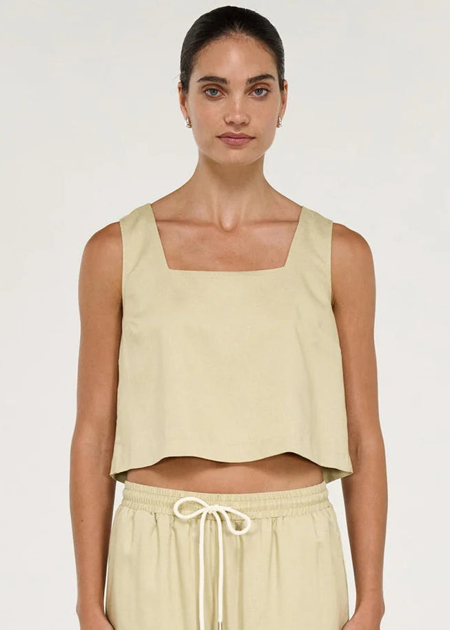 Women wearing short sleeveless beige top on white background