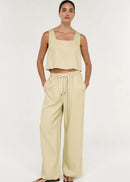 Women wearing short sleeveless beige top on white background