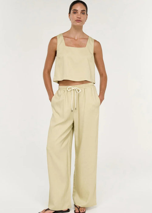 Women wearing short sleeveless beige top on white background