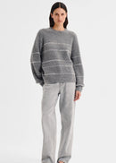 Woman wearing a grey sweater on a white background