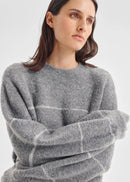 Woman wearing a grey sweater on a white background