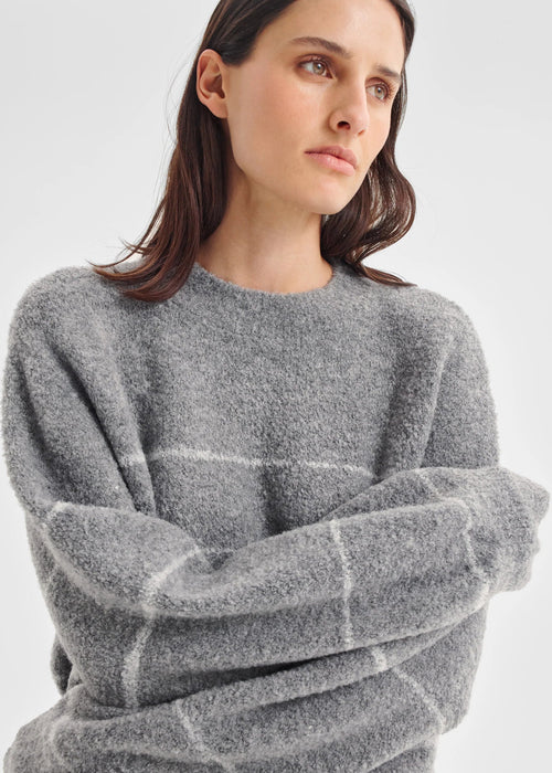 Woman wearing a grey sweater on a white background