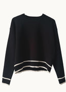 Black and with white stripe sweater on blue background