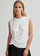 Woman modelling white tee on grey background