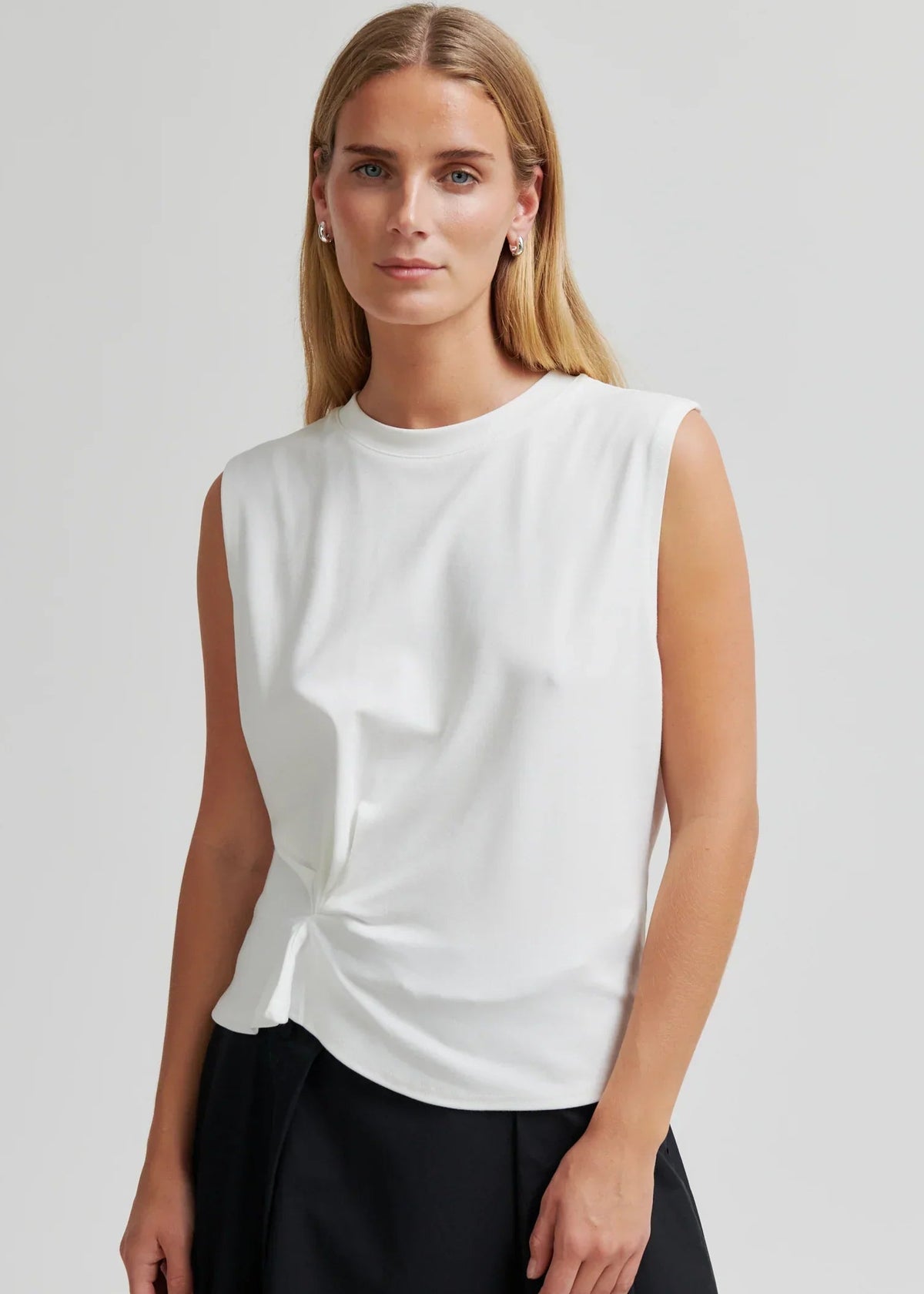 Woman modelling white tee on grey background
