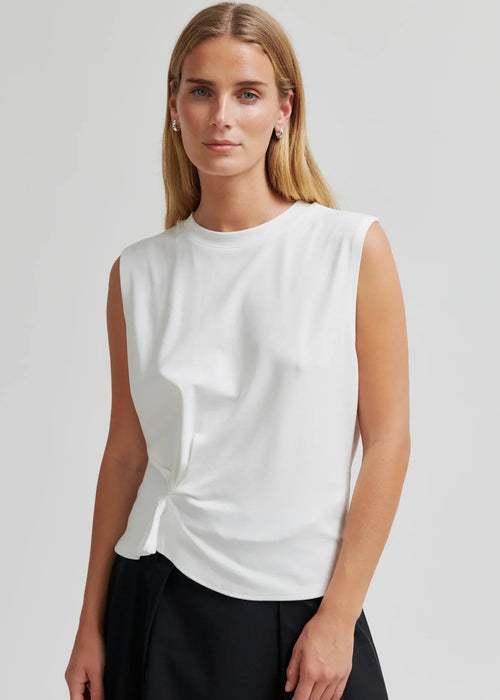 Woman modelling white tee on grey background