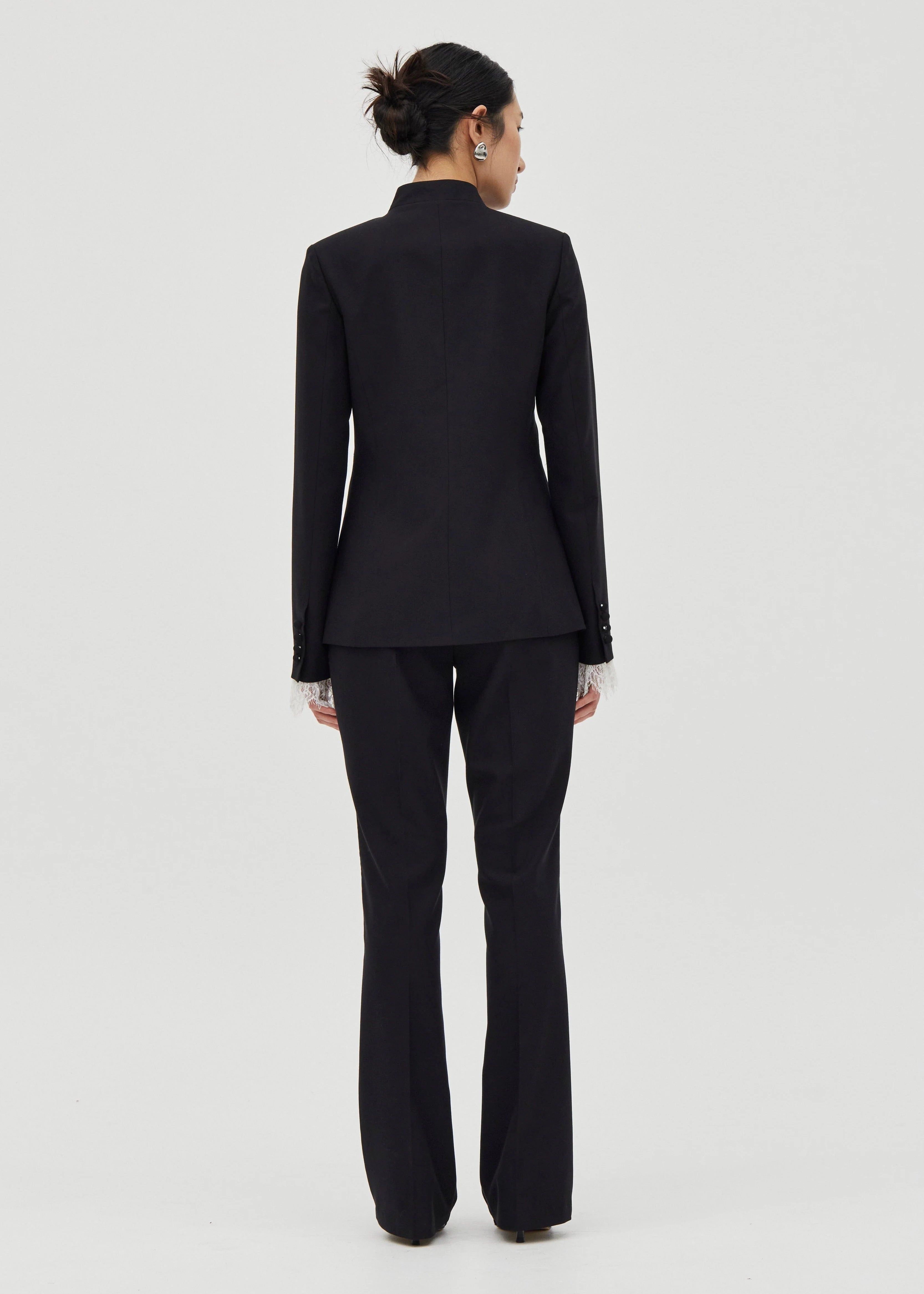 Person wearing a black suit on a white background