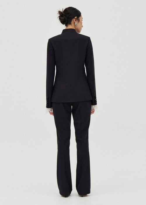 Person wearing a black suit on a white background