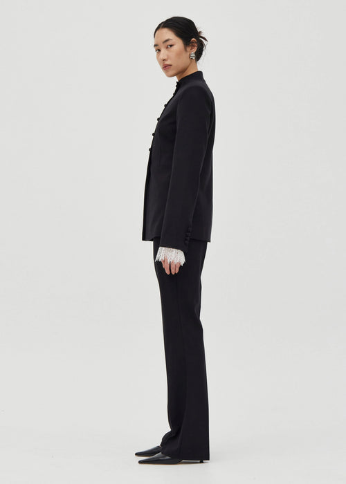 Person wearing a black suit on a white background