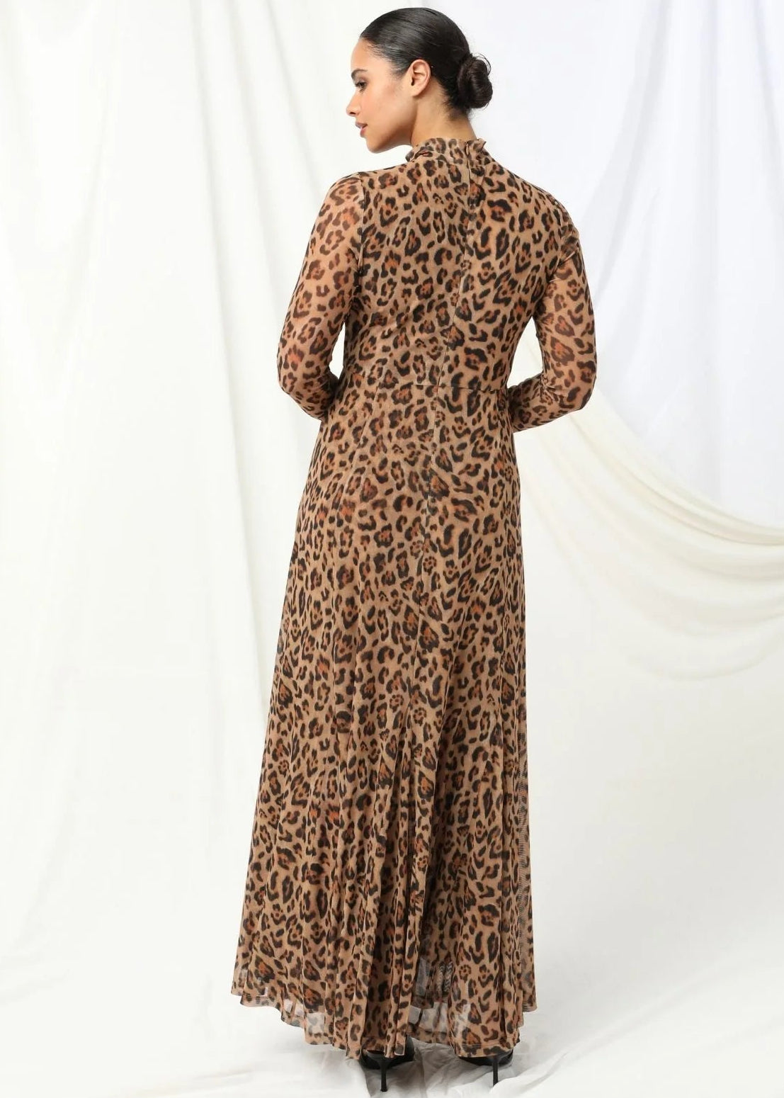 Woman wearing a leopard print dress against a white background