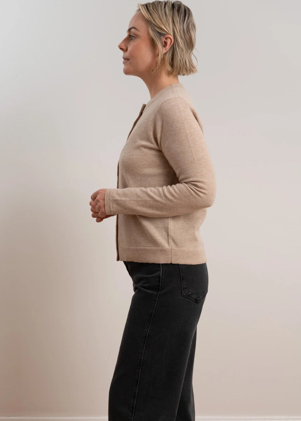 Woman wearing brown cardigan on white background