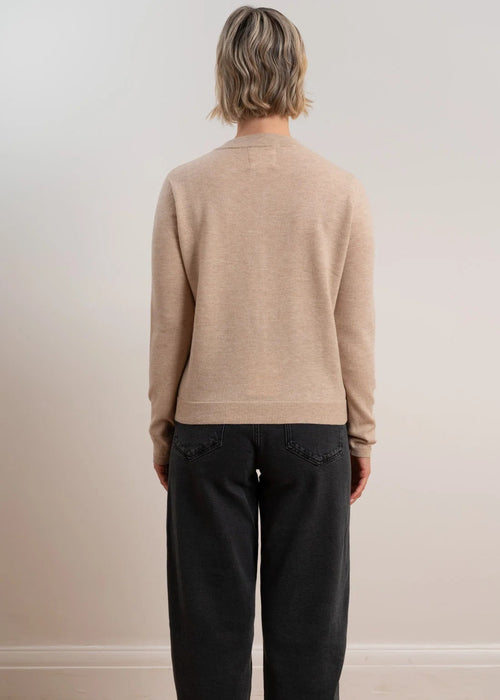 Woman wearing brown cardigan on white background
