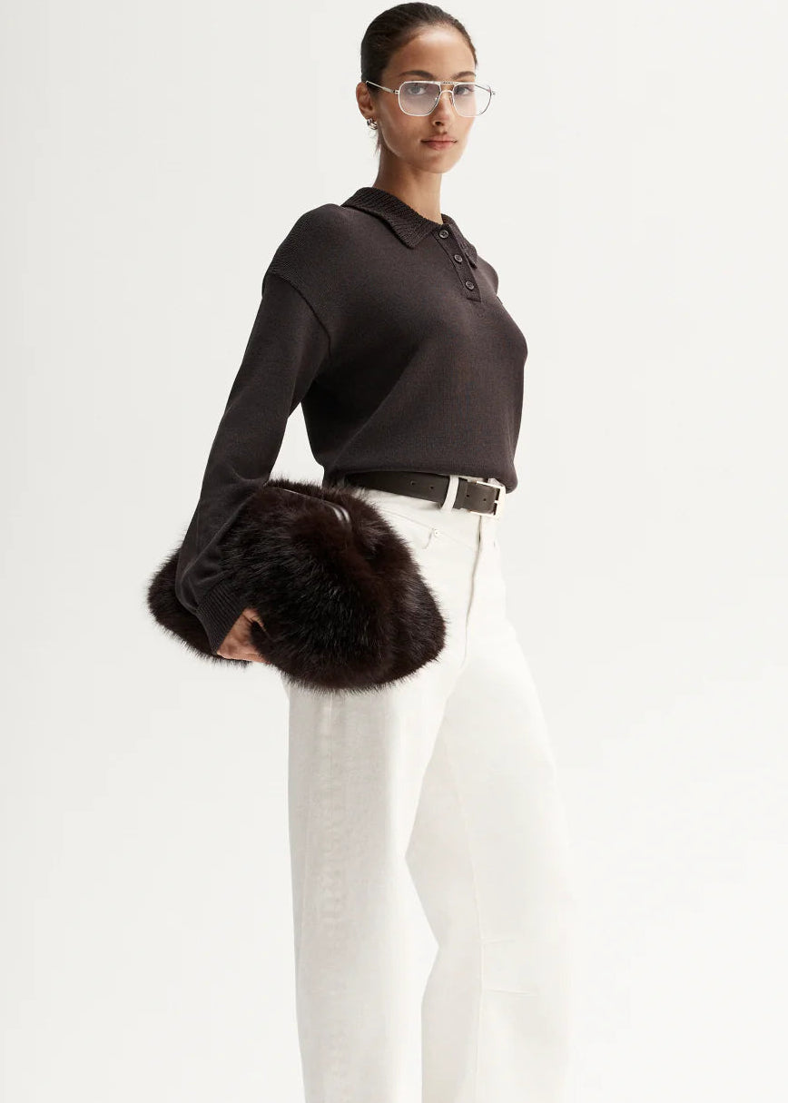 Woman wearing brown knit polo on white background