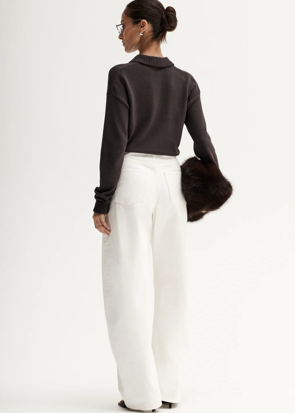 Woman wearing brown knit polo on white background