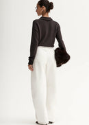 Woman wearing brown knit polo on white background