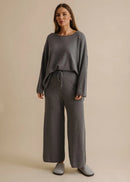 Person wearing grey sweatpants on a beige background