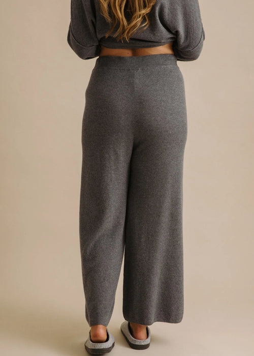Person wearing grey sweatpants on a beige background