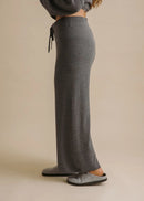Person wearing grey sweatpants on a beige background