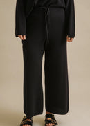 Woman wearing a black outfit on a beige background