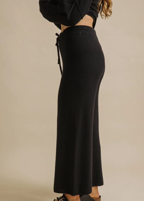 Woman wearing a black outfit on a beige background