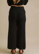 Woman wearing a black outfit on a beige background