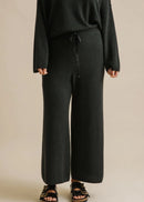 Woman wearing a dark green outfit on a beige background