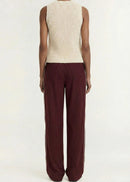 A model shown from the back wearing a cream ribbed sleeveless knit top and dark burgundy wide-leg pleated trousers, set against a plain light gray studio background.