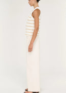 A model stands against a plain light background wearing a sleeveless knit top with thin horizontal beige stripes on an off-white base, paired with off-white wide-leg pants and black sandals.