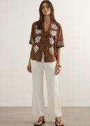 Woman wearing brown top on white background