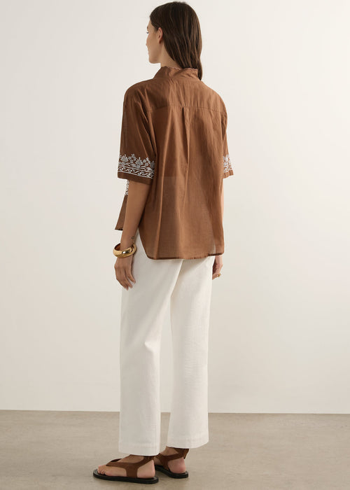 Woman wearing brown top on white background