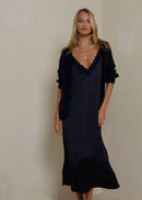 Woman wearing a navy cardigan on grey background