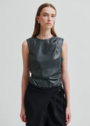 Woman wearing a dark grey sleeveless top on a light grey background