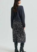 Woman wearing a grey sequin skirt on a light grey background