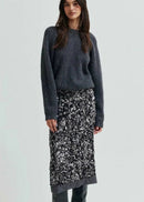 Woman wearing a grey sequin skirt on a light grey background