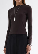 Woman wearing a brown long-sleeve top on a white background.