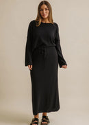 Woman wearing a black skirt with a plain background