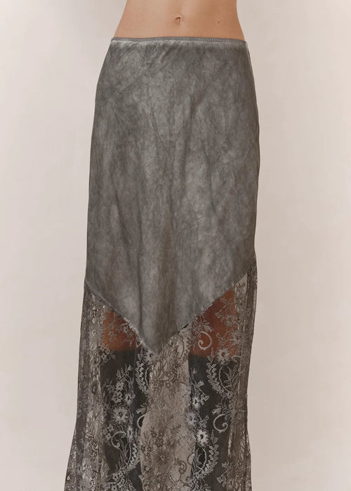 A grey and black lace maxi skirt with a textured, washed finish, shown on a model against a plain light background.