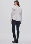 Woman wearing a white shirt, black pants, and black knee-high boots on a white background
