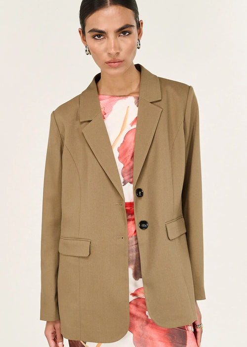 Woman wearing a beige blazer on a white background