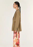 Woman wearing a beige blazer on a white background